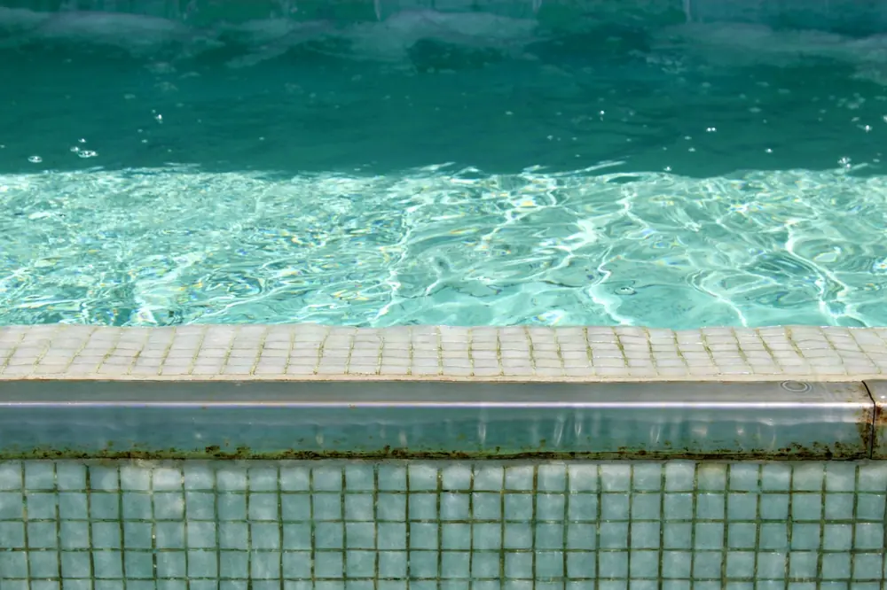 Close-up of clear chlorinated swimming pool water and tiled edge