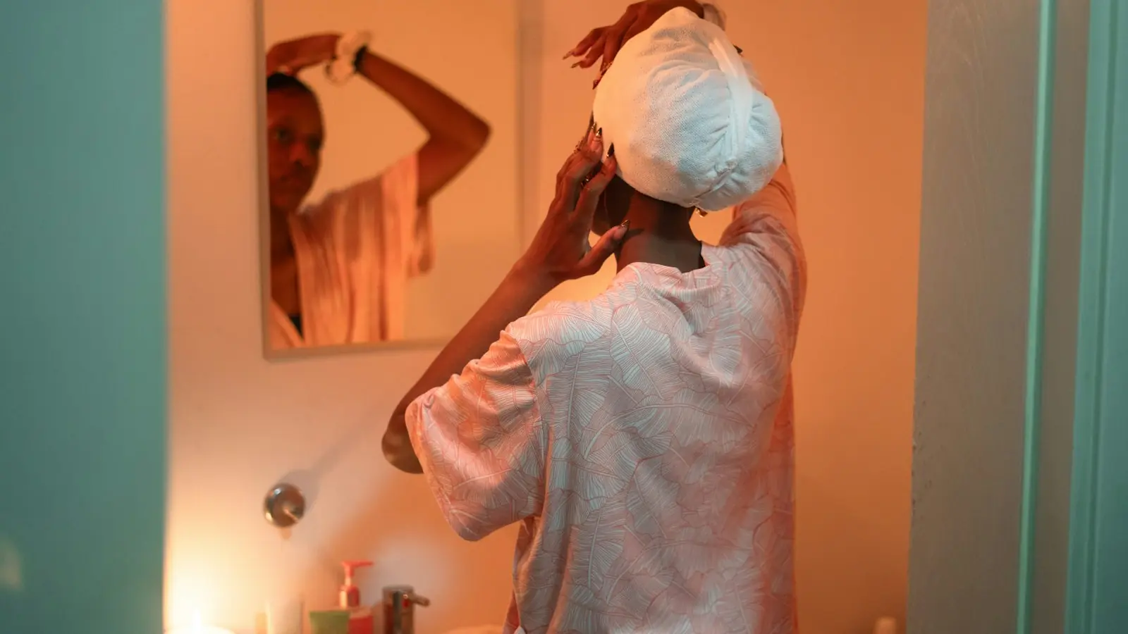 Woman wrapping wet hair in a towel after a shower